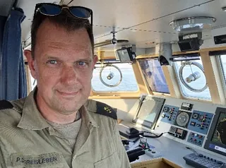 Foto af Christian Søgaard som sidder på en hundeslæde 
