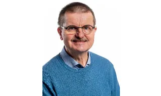  Foto af Henrik Oest, med blå trøje, briller og overskæg 