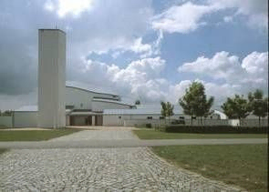 Tornbjerg Kirkes moderne hvide facade, der viser dens unikke arkitektoniske design med rene linjer og et fremtrædende tårn
